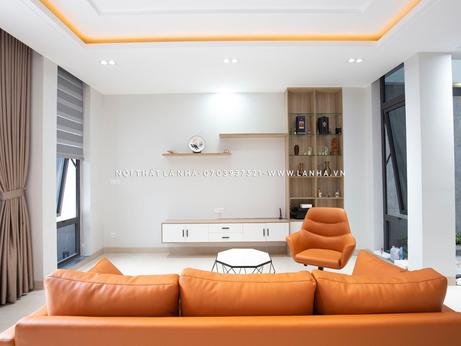 Phòng khách với kệ tủ tivi treo tường cùng bộ sofa màu cam ấn tượng