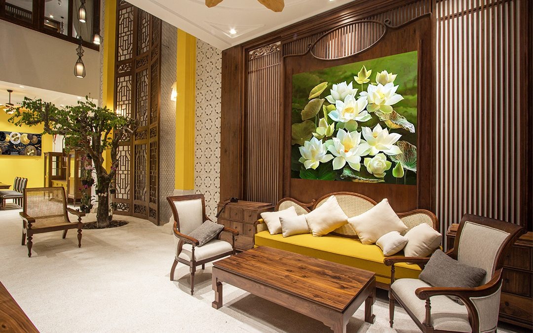 Tường phòng khách được trang trí bằng tranh và đèn trang trí truyền thống, tạo nên một okking.con Indochine đầy lôi cuốn